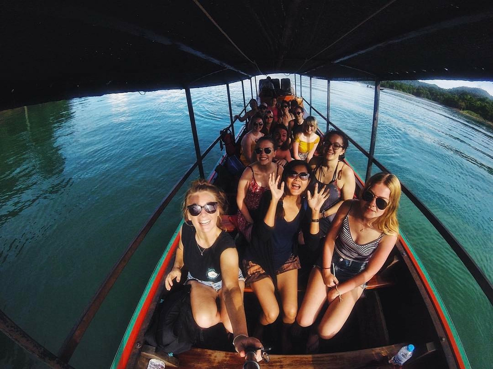Group of people on a boat enjoying the scenic view.