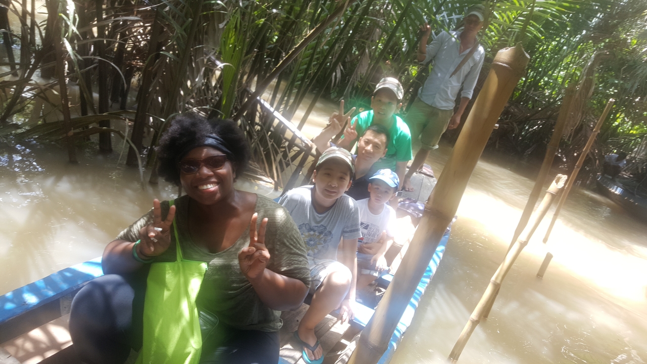 Groupe de personnes assises dans un canoë sur un cours d'eau tropical.