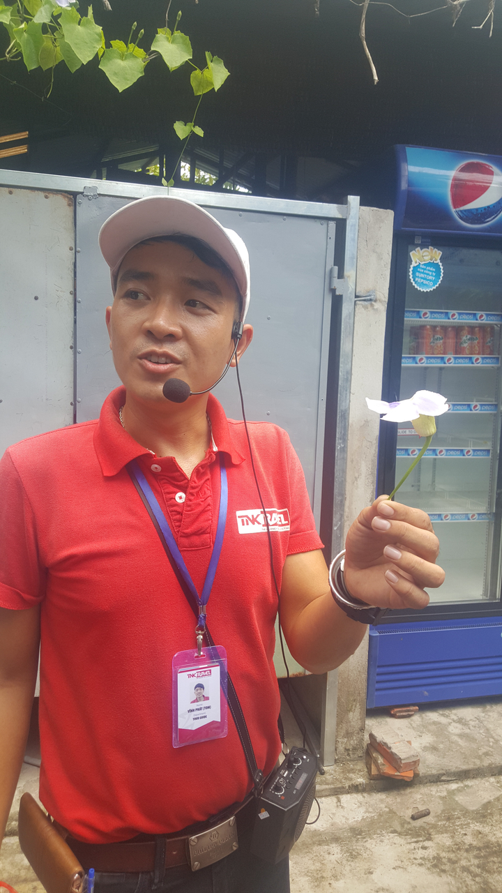 Homme tenant une fleur et parlant avec un casque.