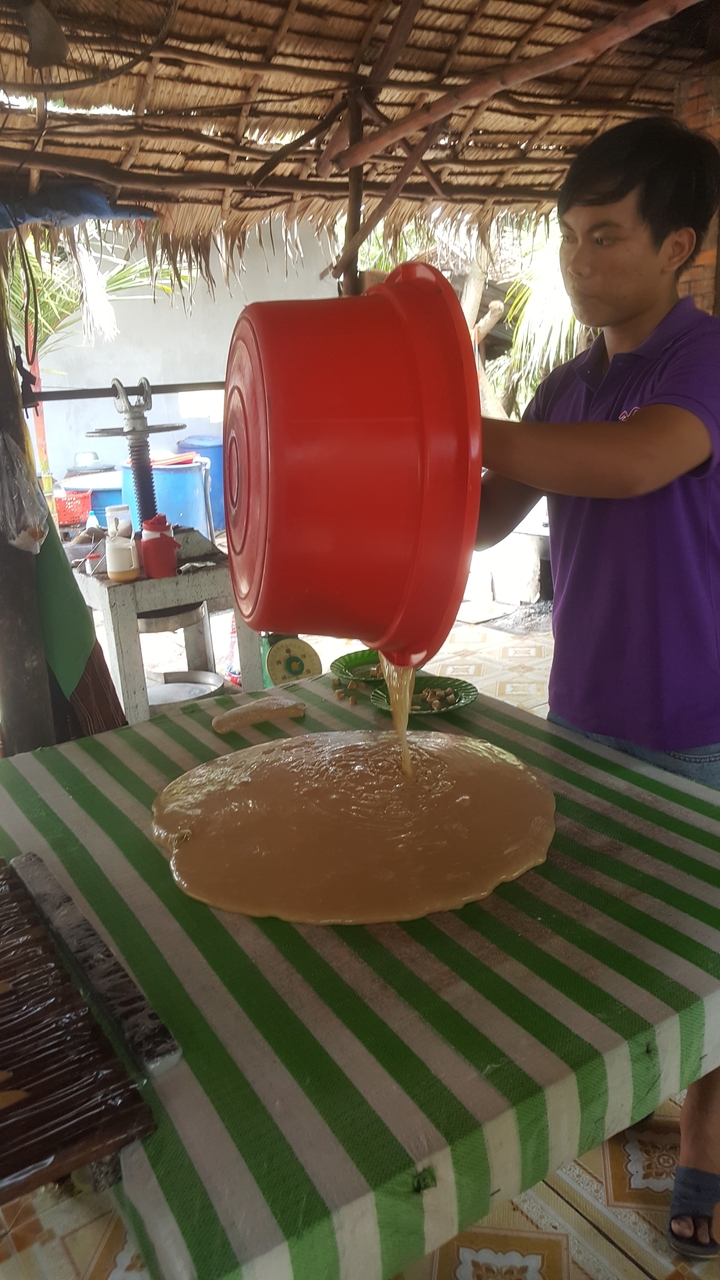 Personne versant un mélange liquide sur une surface plane dans une cuisine.