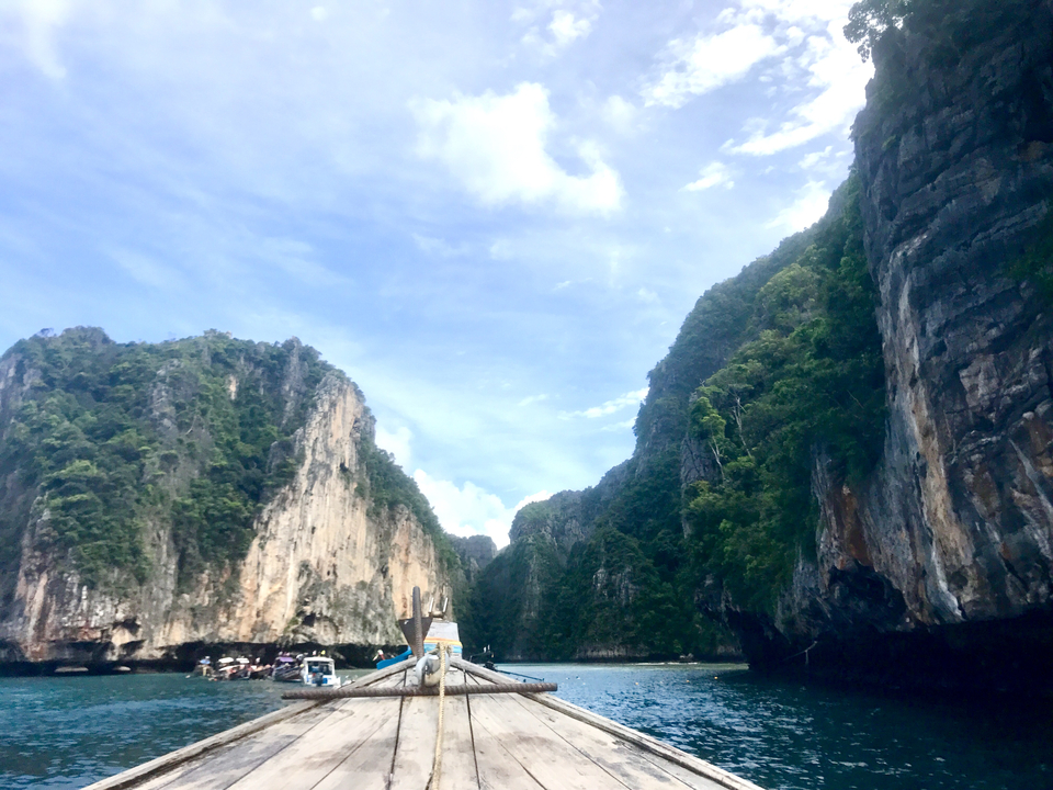 Scenic view of steep cliffs and clear blue water under a bright sky.