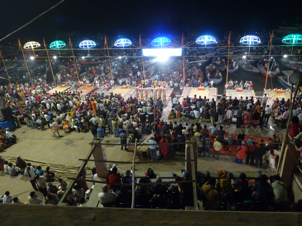 Grand rassemblement en plein air, la nuit, avec des lumières et une rivière.