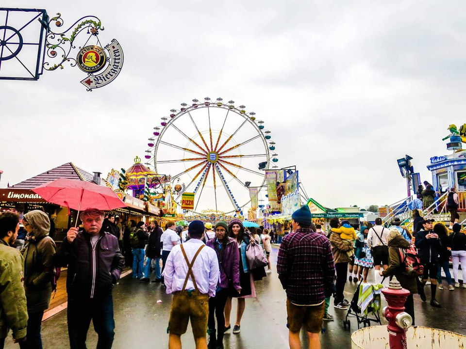Grande foule lors d'un festival en plein air avec une grande roue.
