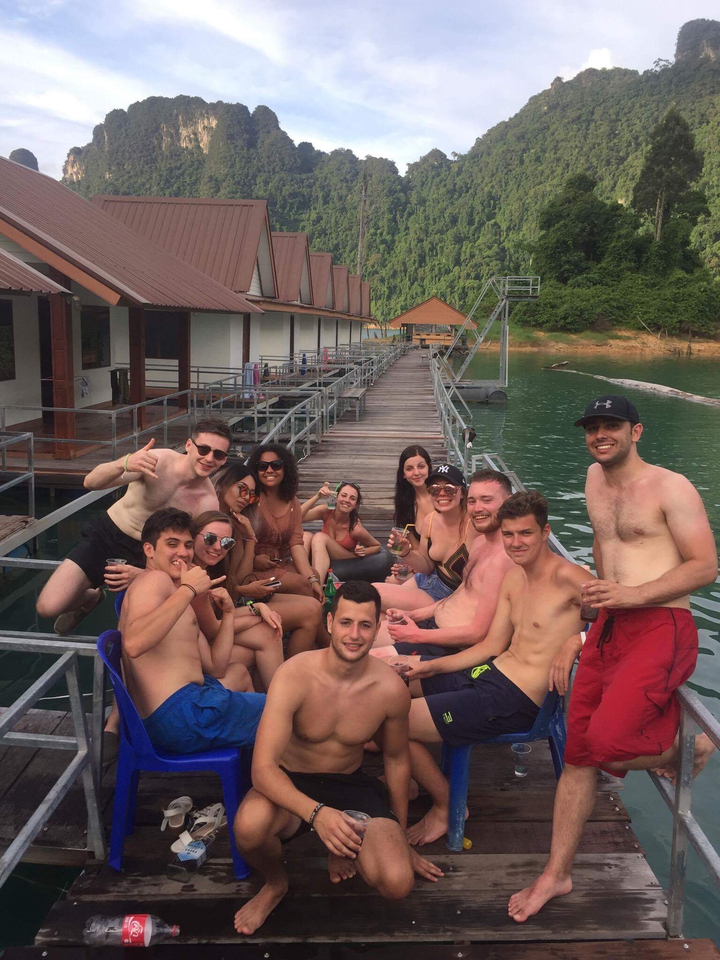 Group relaxing on a dock over the water.