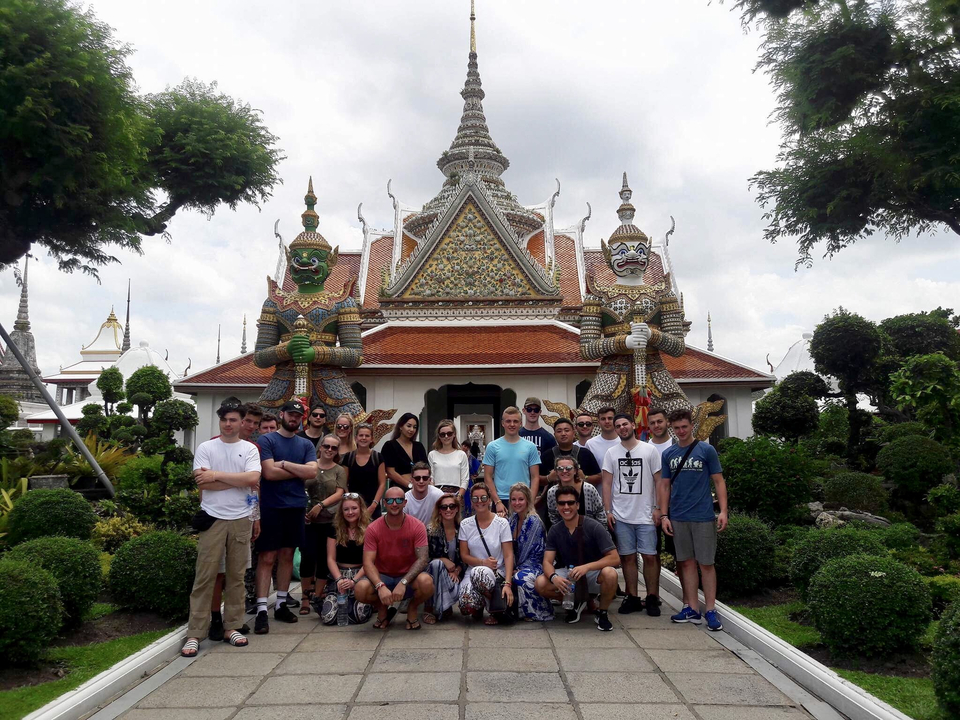 Group in front of a temple with mythical statues.