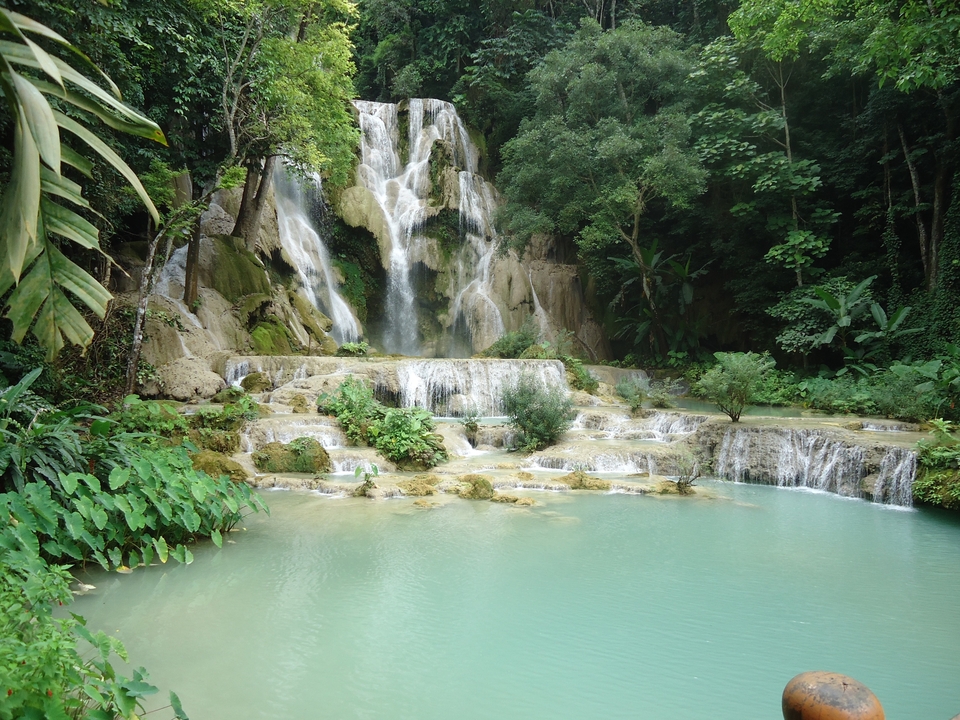 Scenic view of a tiered waterfall surrounded by lush greenery.