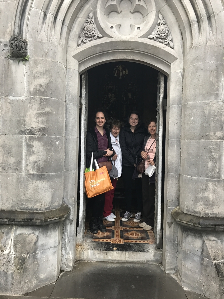 Groupe debout devant une porte en pierre.