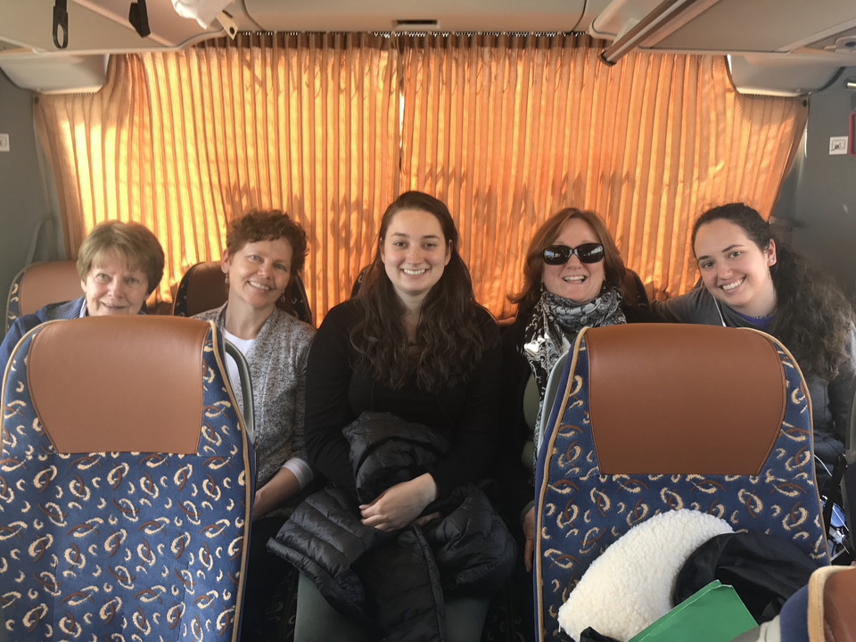 Groupe de personnes assises à l'intérieur d'un bus aux rideaux orange.