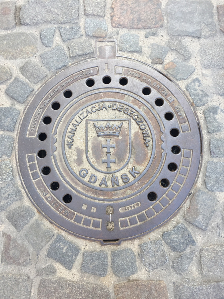 Plaque d'égout avec l'emblème de Gdansks