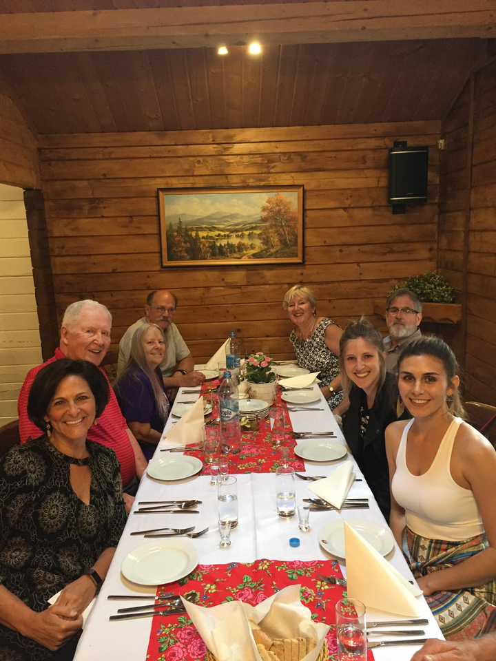 Groupe de personnes assises autour d'une table à manger à l'intérieur d'une cabane en bois.