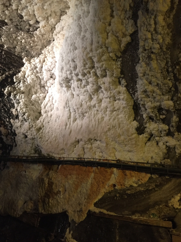 Intérieur d'une mine de sel avec des minéraux sur les murs et une passerelle.