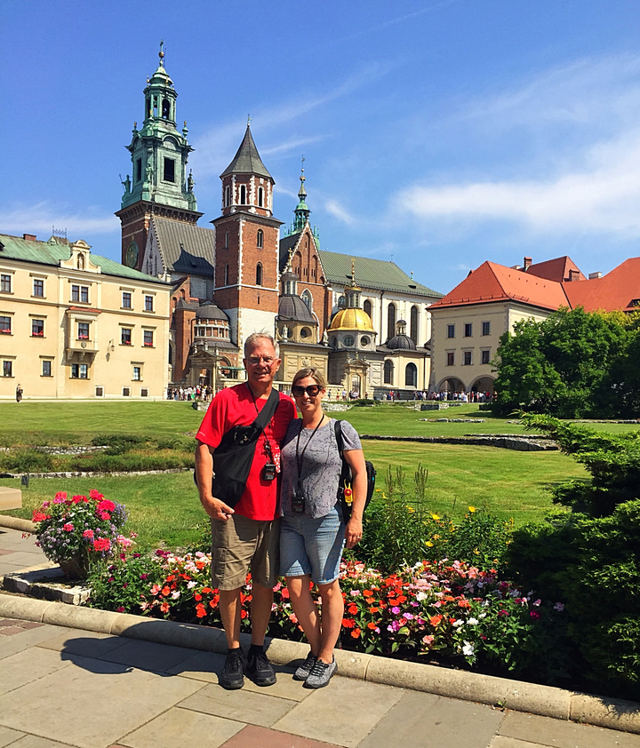 Touristes devant un château avec jardin.