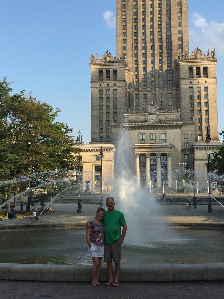Fontaine devant un bâtiment historique dans un cadre urbain.