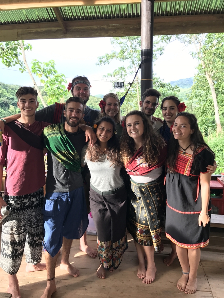 Group of people in traditional attire posing outdoors.
