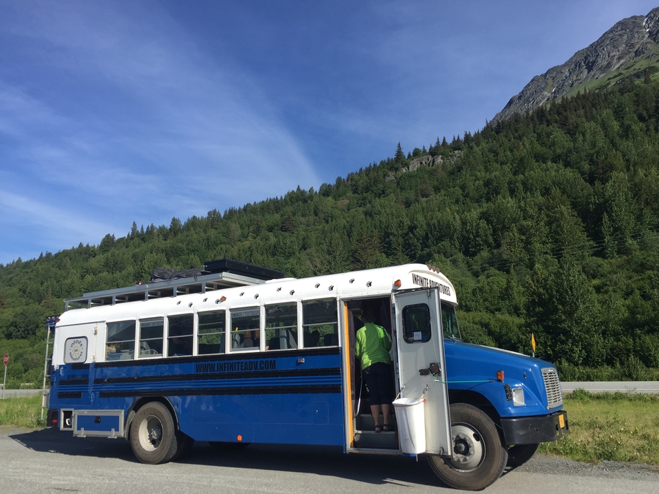 Bus bleu avec des personnes dans une forêt