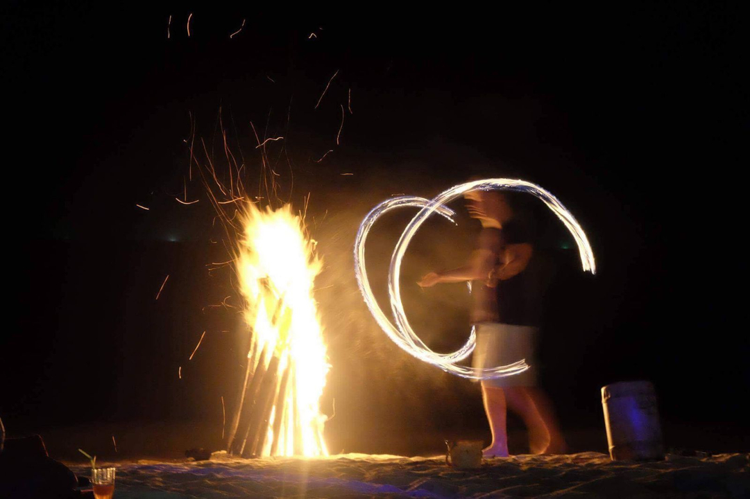 Person performing fire dance at night.