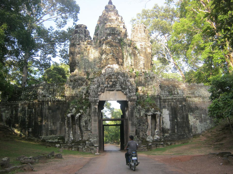 Ancienne porte en pierre entourée d'arbres.