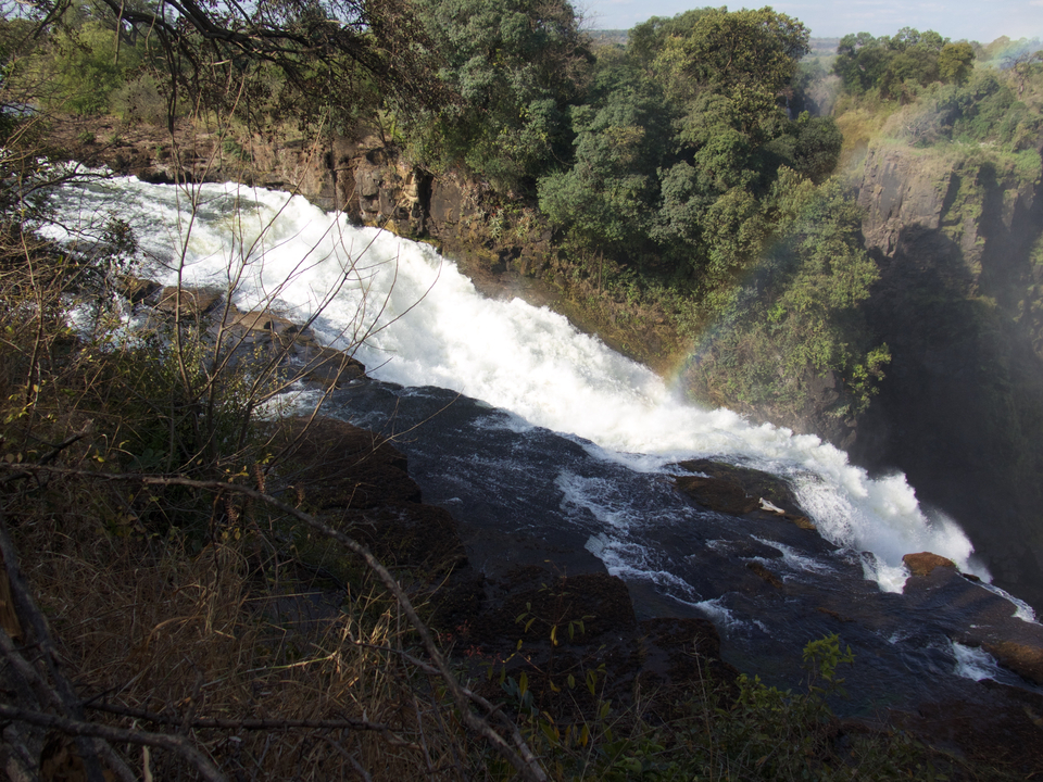 Un point de vue sur une chute d'eau avec un arc-en-ciel.