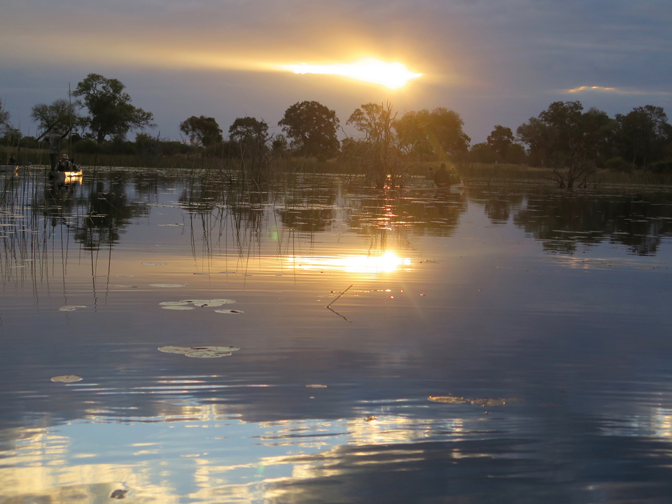 Coucher de soleil sur une étendue d'eau avec des reflets.