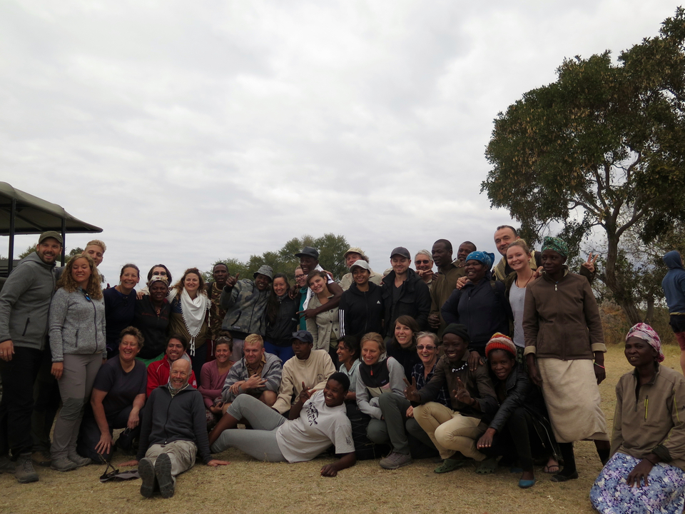 Grand groupe de personnes posant en plein air.