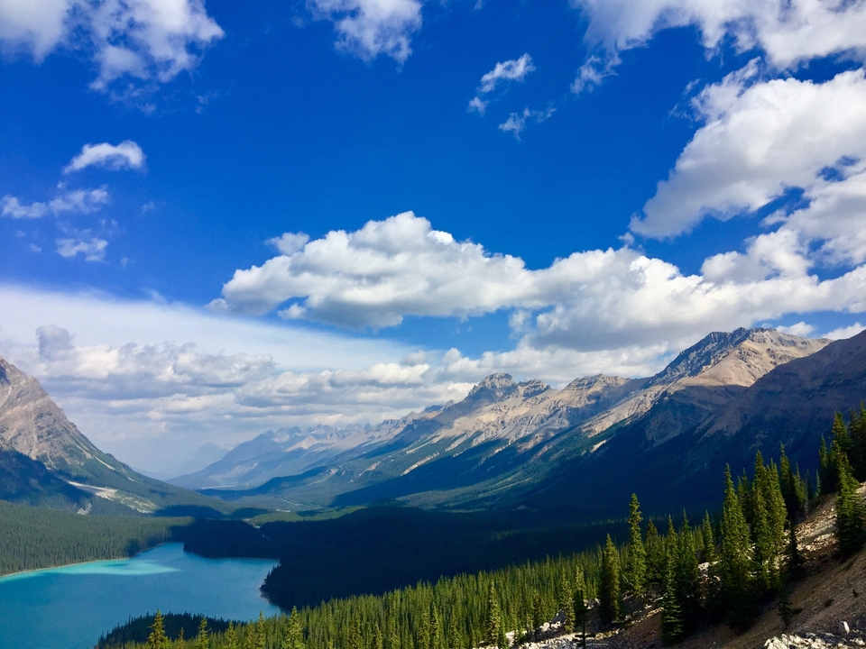 Chaîne de montagnes avec une vallée et une rivière au loin.