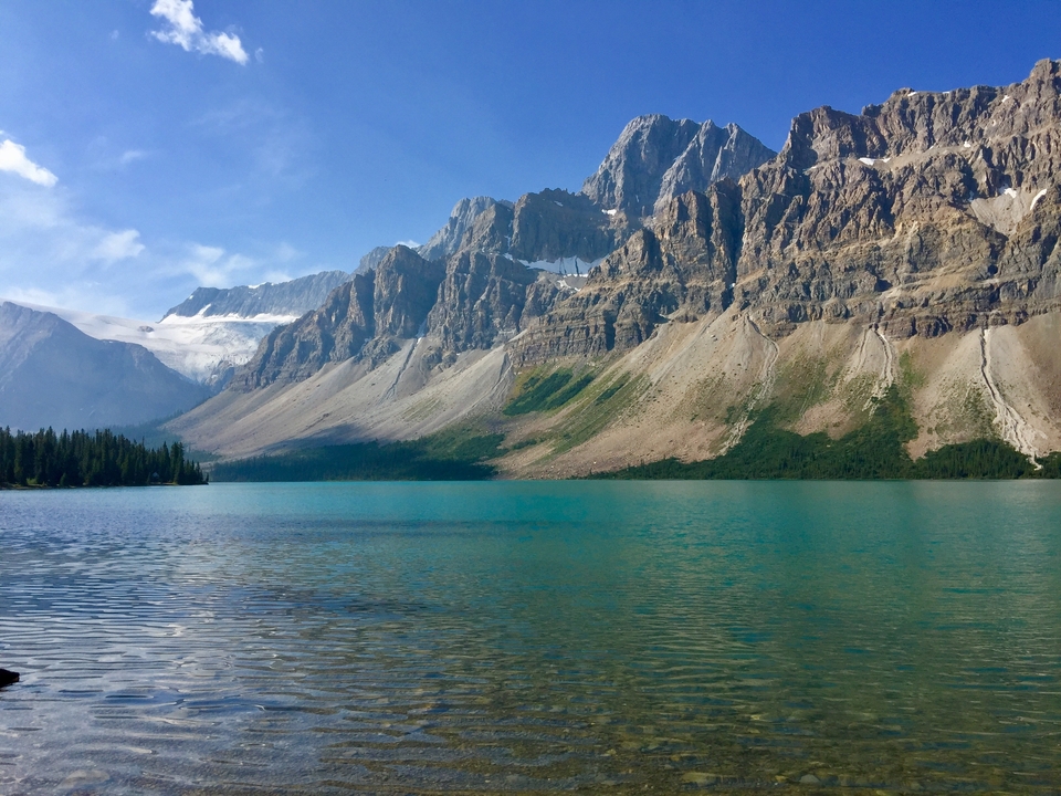 Un lac entouré de montagnes imposantes et un ciel dégagé.