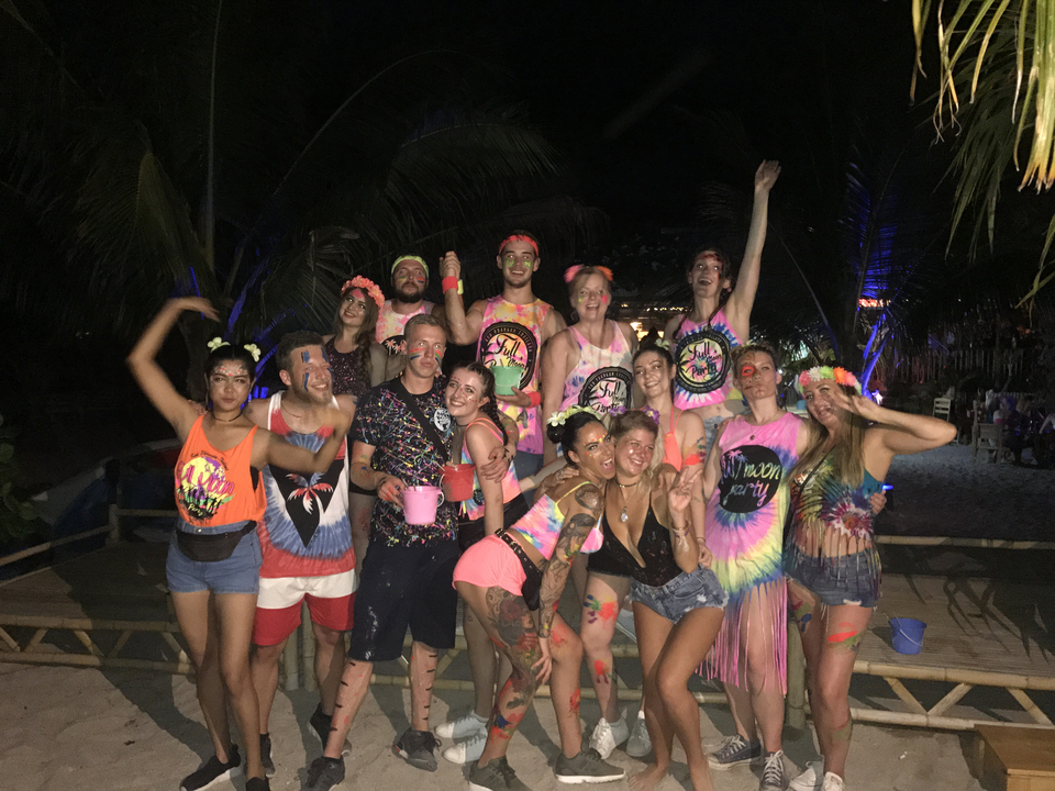 Group of friends in colorful attire at a beach party.