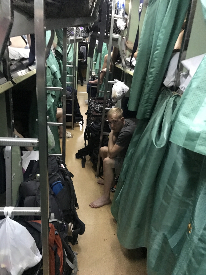 Person seated inside a cramped train compartment.