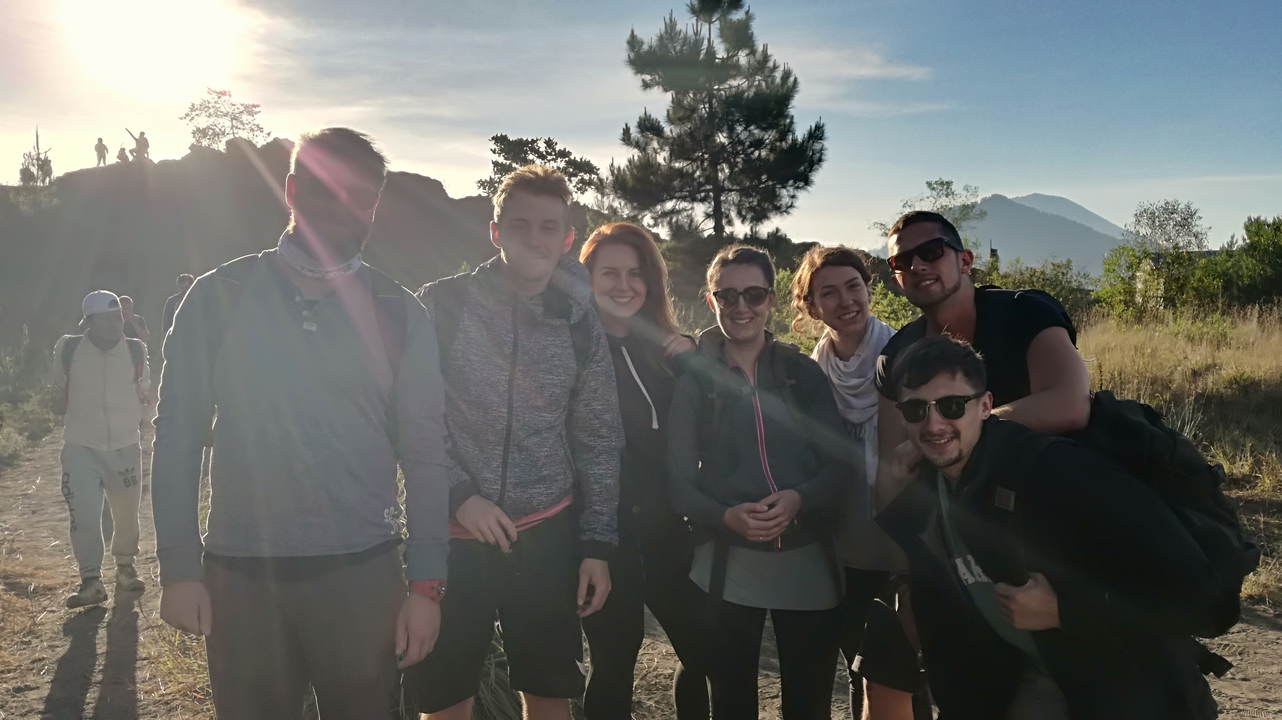 Group of friends posing during a hike with mountains in the background.