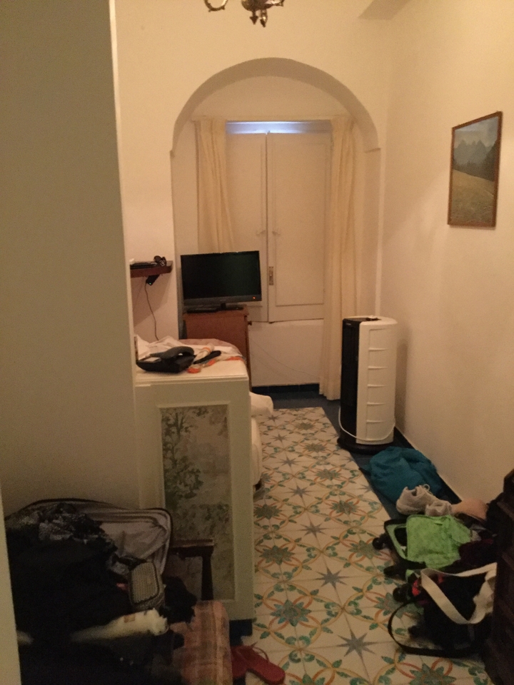 Une petite pièce avec un lit, une télévision et un purificateur d'air.