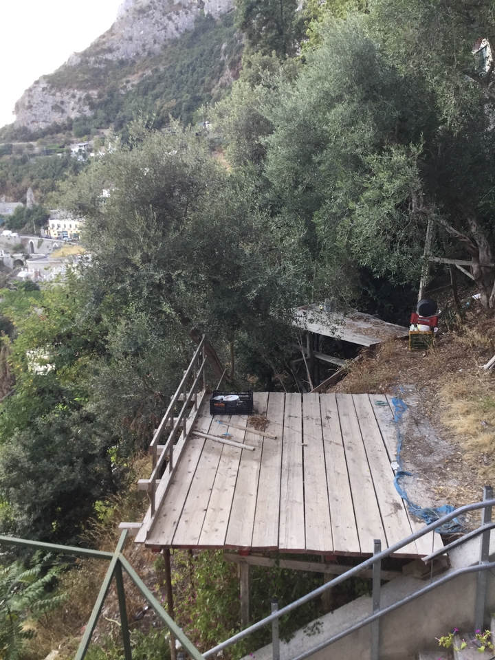 Terrasse rustique en bois avec vue sur les arbres et la vallée.