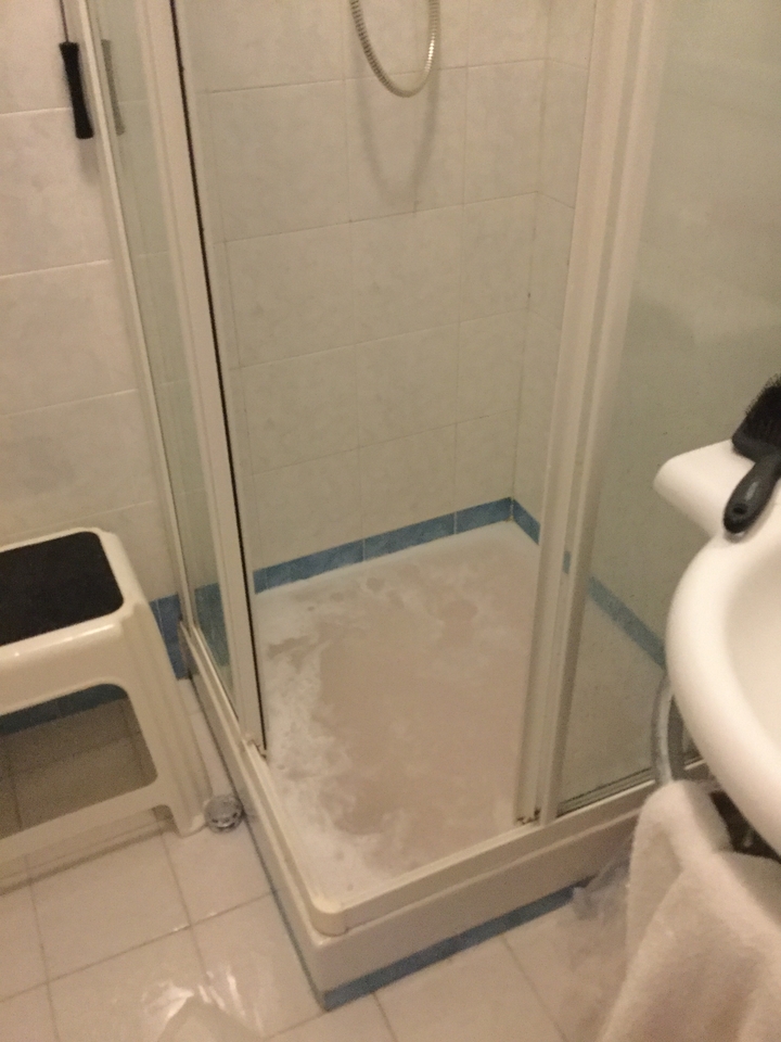 Une douche de salle de bain avec un tabouret à l'intérieur.