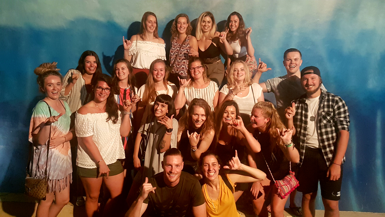 A group of people posing in front of a blue background.