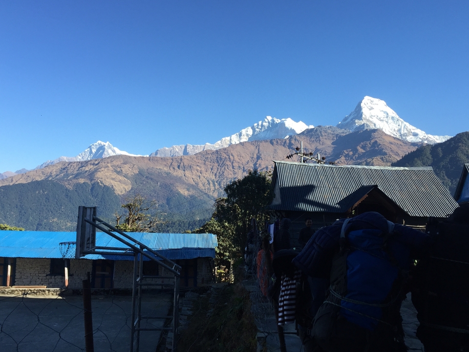Paysage montagneux avec des sommets enneigés et un village.