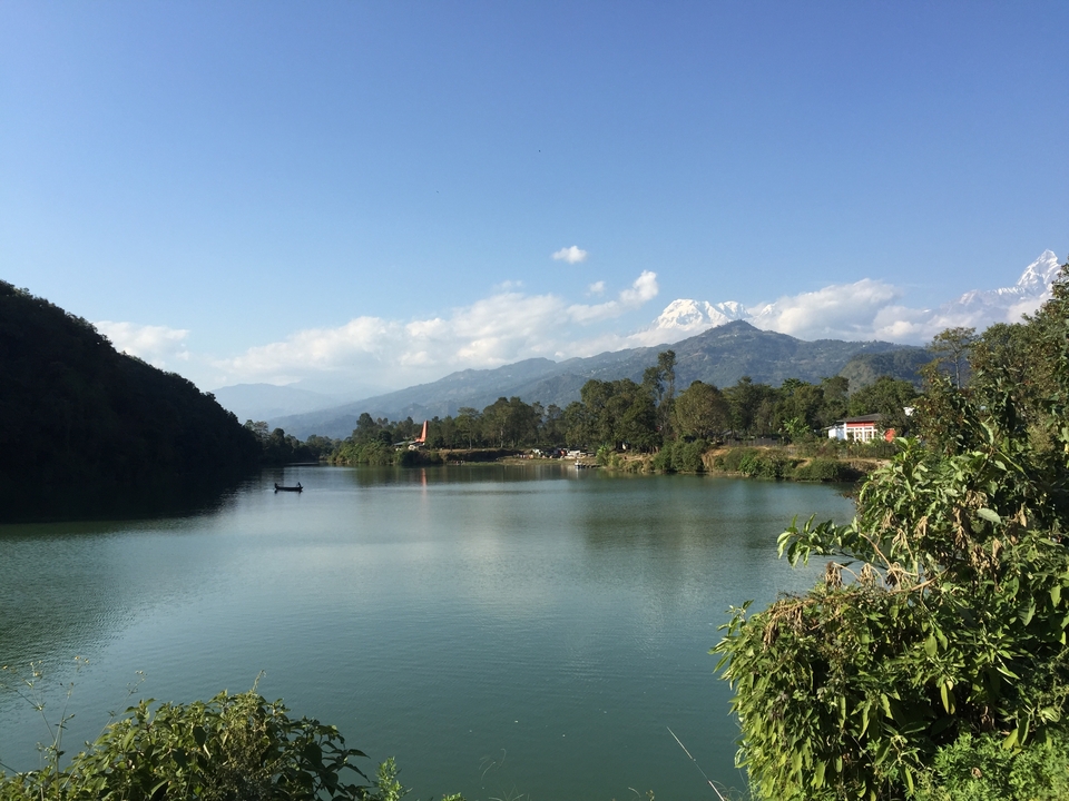 Lac paisible avec des rives bordées d'arbres et des montagnes en toile de fond