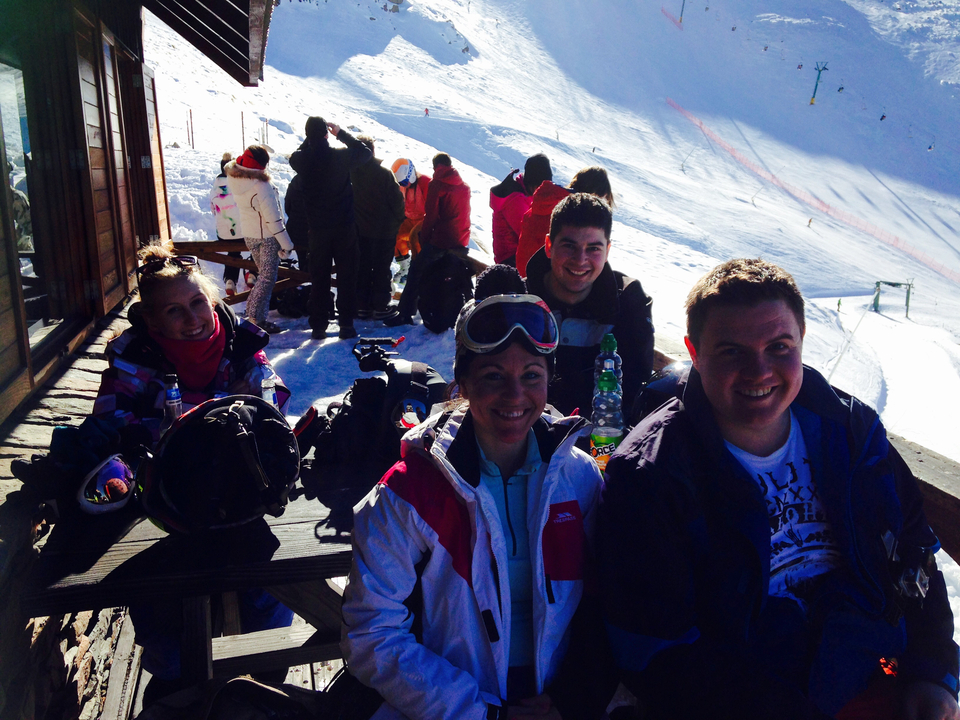 Groupe d'amis dans une station de ski à l'extérieur d'un chalet.