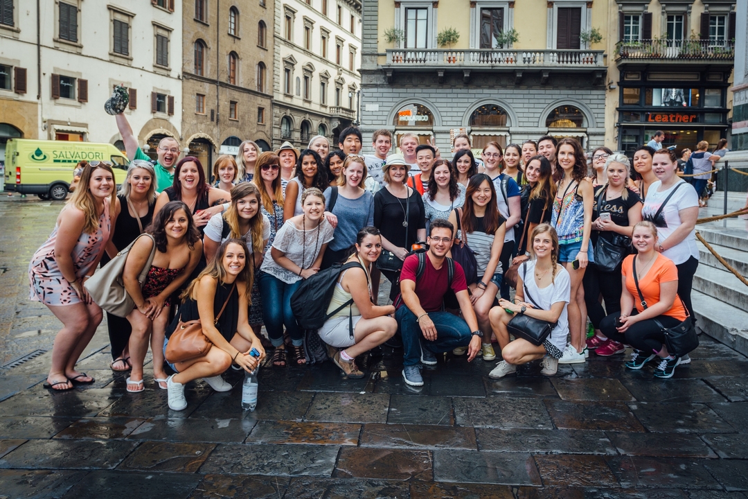 Large group of people posing in a city street.