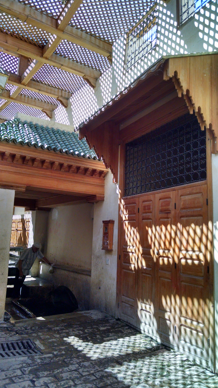 Cour avec des détails en bois ornés et des ombres.