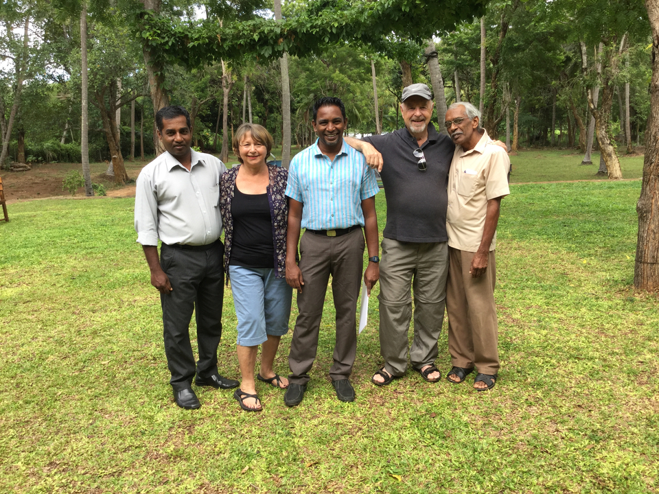 Group of people posing together on the grass.