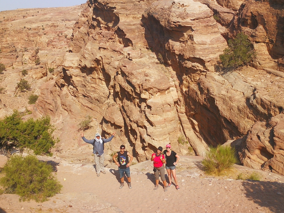 Quatre personnes posant au milieu de falaises rocheuses.