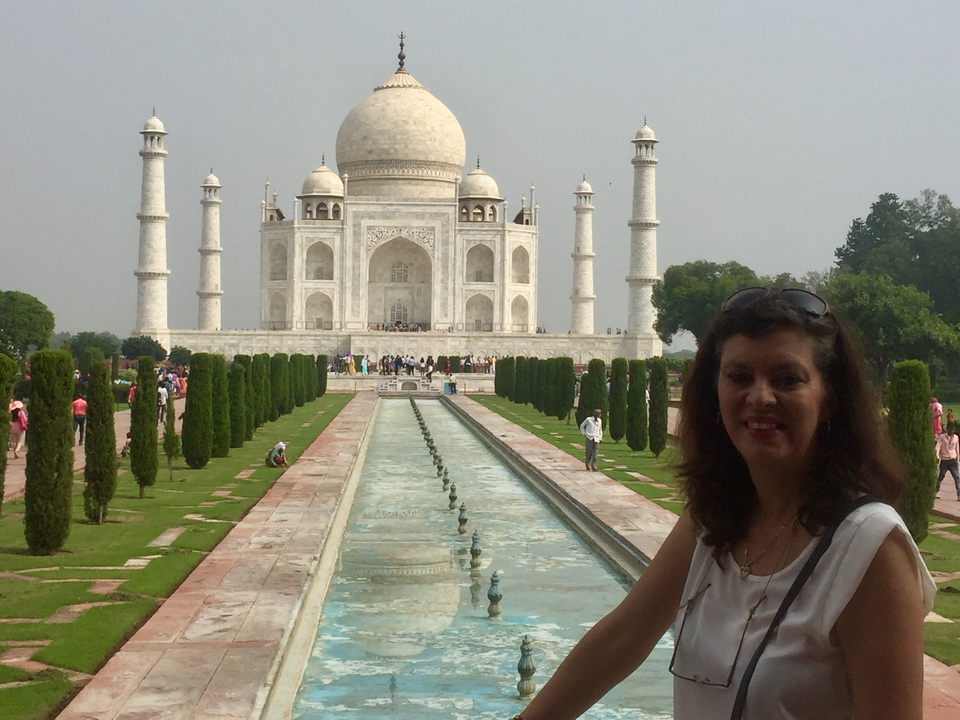 Femme debout devant le Taj Mahal avec un bassin réfléchissant.