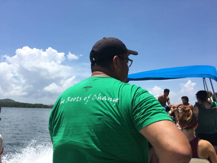 People on a boat with a man in a green t-shirt.