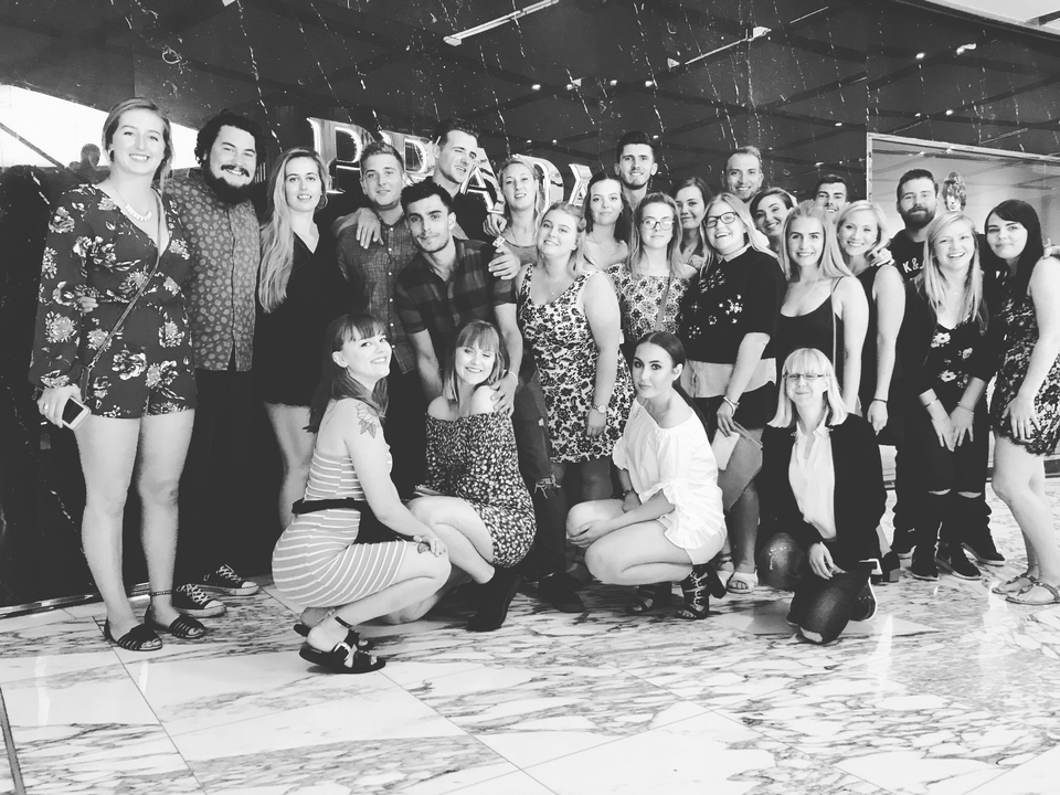 A large group of people posing together indoors in black and white.