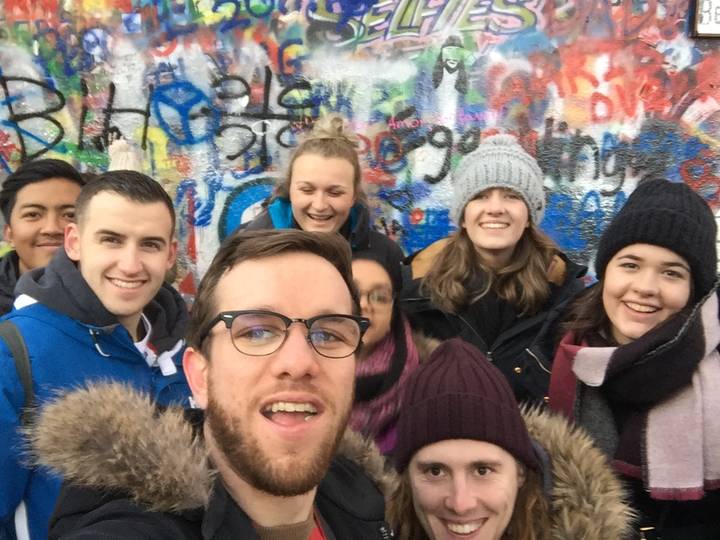 Groupe de personnes devant un mur de graffitis colorés à l'envers.