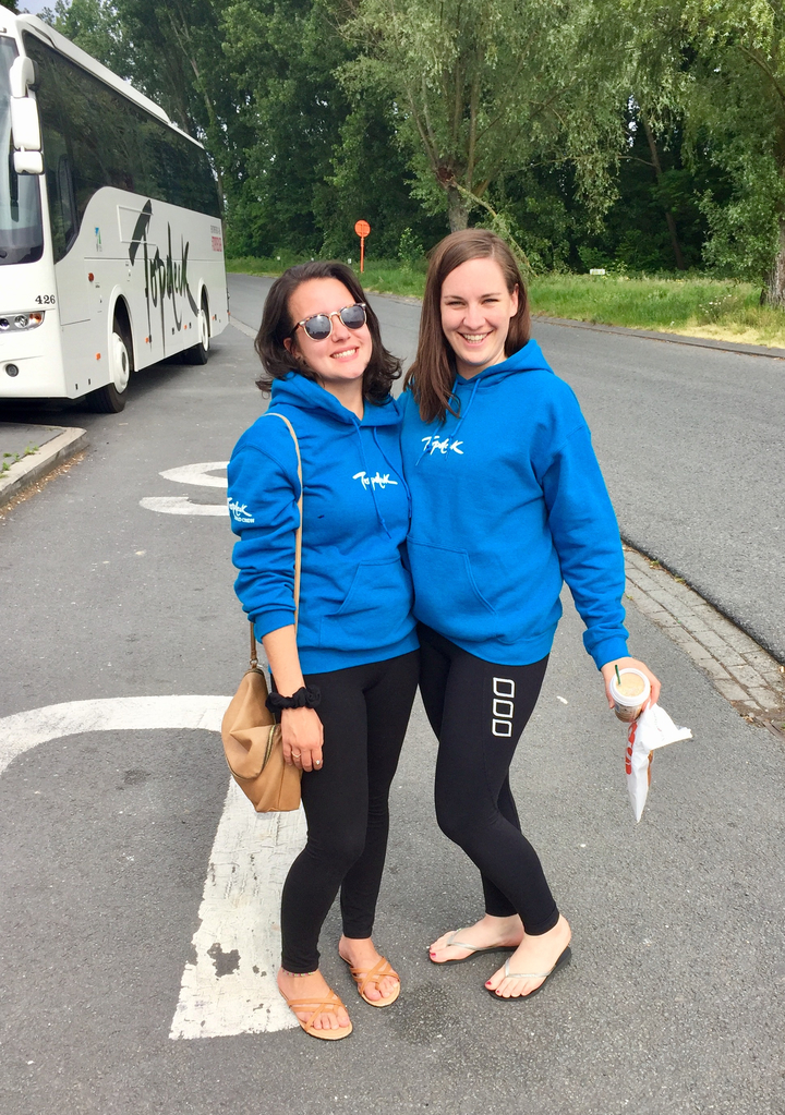 Deux femmes portant des sweats à capuche assortis se tiennent dans une rue.