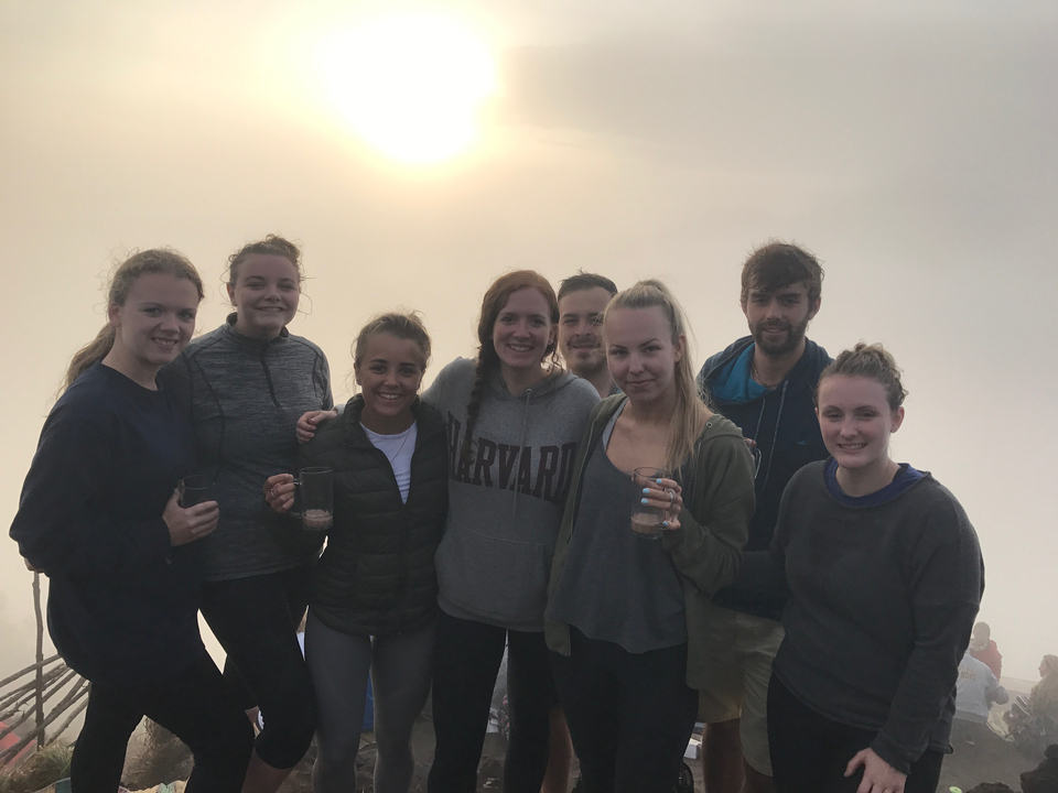 Group of friends posing at a foggy viewpoint.
