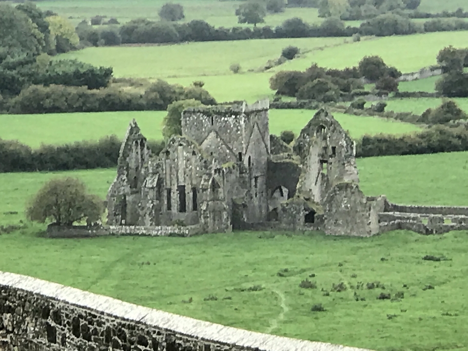 Château en ruine sur un terrain verdoyant.