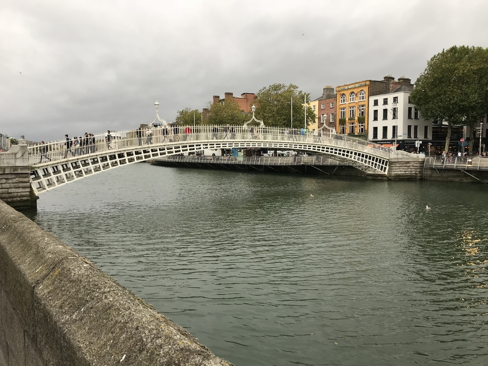 Un pont au-dessus d'une rivière avec des bâtiments urbains en arrière-plan.