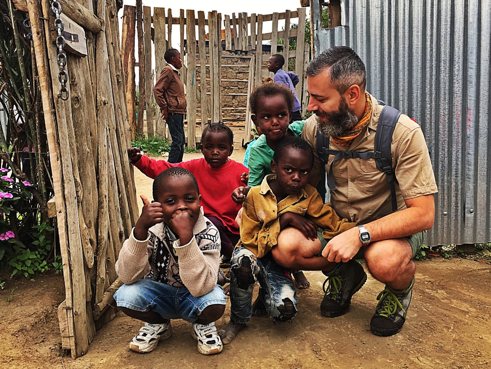 Groupe d'enfants et un adulte assis par terre.