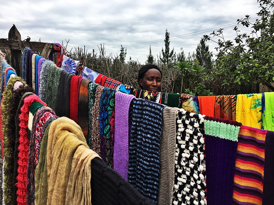 Personne derrière un tissu aux couleurs vives exposé à l'extérieur.